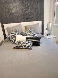 a bed with black and white pillows on it at Appartamento vista oceano a pochi passi dal mare in Playa Fañabe
