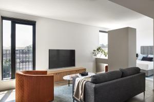 a living room with a couch and a tv at Punthill Parramatta in Sydney