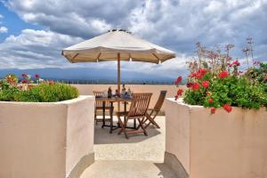 a table with an umbrella on the beach with flowers at Peaks Hotel Nanyuki in Nanyuki