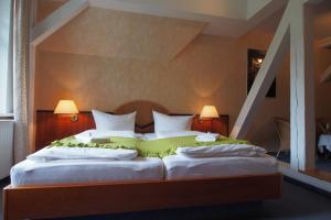 um quarto com uma cama grande e 2 almofadas em Hotel Schlossvilla Derenburg em Derenburg