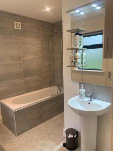 a bathroom with a sink and a bath tub at Cheerful 3 bedroom cottage with great seaview in Drogheda