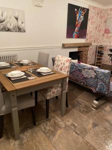 a dining room with a table and chairs and a fireplace at Valley Views in Llwyn-y-pia