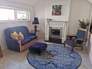 a living room with a blue couch and chairs and a fireplace at The Shoemaker's Cottage in Richmond