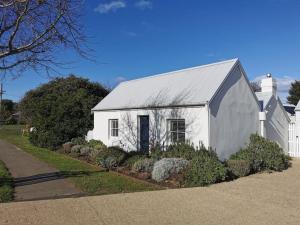 a white building with a gray roof at The Shoemaker's Cottage in Richmond