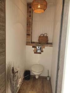 a bathroom with a toilet and a basket on the wall at Instant secret in Pourrières
