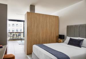 Schlafzimmer mit einem großen Bett mit einem Kopfteil aus Holz in der Unterkunft Punthill Parramatta in Sydney