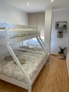ein weißes Etagenbett in einem Zimmer mit in der Unterkunft UIM Mediterraneo Virgen del Carmen 1 Wifi in Puerto de Sagunto