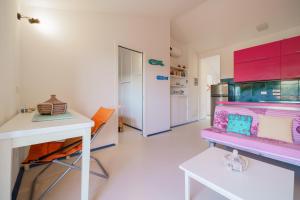 a room with a desk and a table and a kitchen at Cala Azzurra a Fetovaia - Goelba in Fetovaia +8 photos