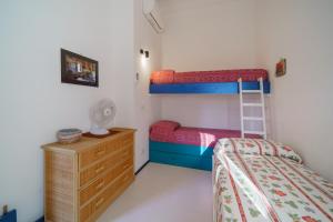 1 Schlafzimmer mit 2 Etagenbetten und einer Kommode in der Unterkunft Cala Azzurra a Fetovaia - Goelba in Fetovaia