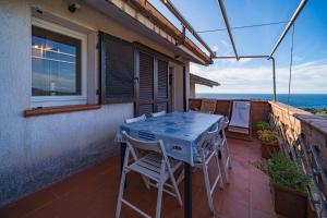 a table and chairs on the balcony of a house at Cala Azzurra a Fetovaia - Goelba in Fetovaia