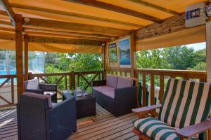 - une terrasse couverte avec 2 chaises et une table dans l'établissement Les Roulottes Pomponnaises, à Saint-Pompont