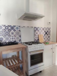 cocina con fogones blancos horno de arriba junto a un mostrador en Casa nel borgo nella natura en Pettorano sul Gizio