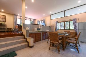 a kitchen and dining room with a table and chairs at Suanphung Bonsai Village in Ban Bo Wi