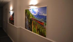 a large painting of a train on a wall at Railway Hotel in Almaty