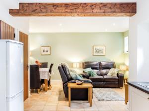 a living room with a leather couch and a table at Riding Cottage - Uk37449 in Pateley Bridge