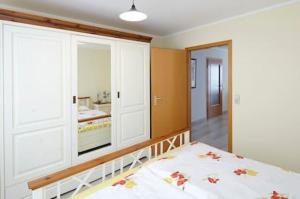 1 dormitorio con cama y espejo grande en Komfortferienwohnung Zentrum, en Ludwigsburg