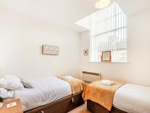 a bedroom with two beds and a window at Riding Cottage - Uk37449 in Pateley Bridge