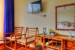 Zimmer mit einem Tisch, 2 Stühlen und einem TV in der Unterkunft Peaks Hotel Nanyuki in Nanyuki