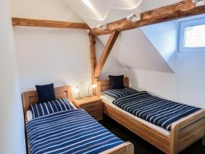 two beds in a room with wooden beams at Gästezimmer im Weingut Wolf in Großkarlbach