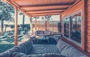 a screened in porch with couches and a table at Marina House Primero in Grado