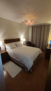 アングラ・ド・エロイーズモにあるTelhados d'Angra ALのベッドルーム(大きな白いベッド1台、シャンデリア付)