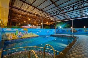 a large swimming pool with a mural on the wall at Hotel Jagadguru Lonavala in Lonavala