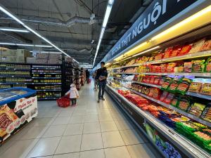 Ein Mann und ein Kind gehen durch einen Supermarkt-Gang. in der Unterkunft Papilio Homestay Tay Ho in Hanoi