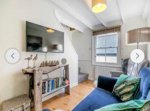 a living room with a blue couch and a tv at Fulmar Cottage in Mevagissey