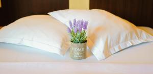 - un vase avec des fleurs assis sur un lit avec des oreillers dans l'établissement Pensiunea mălin și răzvan (chillbrothers), à Băile Felix