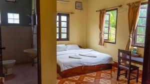 a bedroom with a bed and a sink and a toilet at Mao Pha Sok Guesthouse in Luang Prabang