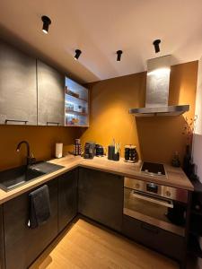 a kitchen with a sink and a stove top oven at Intimate - Private Wellness in Héron