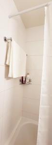 Baño blanco con bañera y toalla en Apartahotel Confort en Lausana