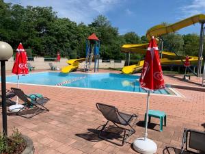 桑特伊阿的住宿－Piscina San Lorenzo，一个带椅子的游泳池和一个带滑梯的游乐场