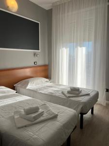Habitación de hotel con 2 camas y TV de pantalla plana. en Hotel Stella D'Italia en Rímini