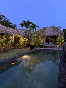 a swimming pool in front of a villa at night at La Reserva Villas Bali in Jimbaran
