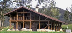 a log cabin in the middle of a field at Baita Misonet in Comano Terme