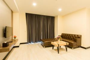 - un salon avec un canapé et une table dans l'établissement Crystal Palace Luxury Hotel Pattaya, à Pattaya (nord)