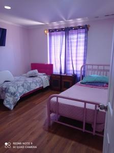 sypialnia z 2 łóżkami i oknem w obiekcie Casa San Francisco w mieście Los Andes