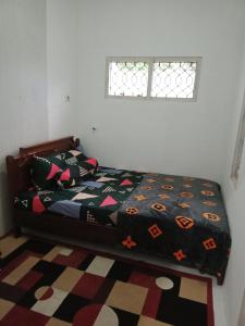 ウォノソボにあるMutiara Diengのベッドルーム1室(ベッド1台、掛け布団、窓付)