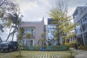 una casa blanca con un coche aparcado delante de ella en DERA Resort & Spa en Cox's Bazar