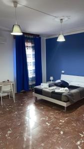 1 dormitorio con 1 cama con pared azul en Guest House Vecchi, en Reggio Emilia