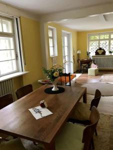 a living room with a wooden table with a vase on it at Romantischer Villenteil in der Barock- und Musikstadt Ochsenhausen in Ochsenhausen