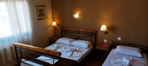 two twin beds in a room with two lamps at Vanta Hotel in Limenas