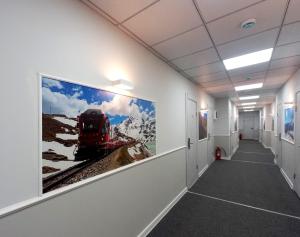 a hallway with a large painting of a train on the wall at Railway Hotel in Almaty +28 photos