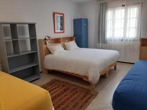 a bedroom with a large bed and a blue cabinet at La Maison Jaune Dakhla Maison d'hôtes in Dakhla