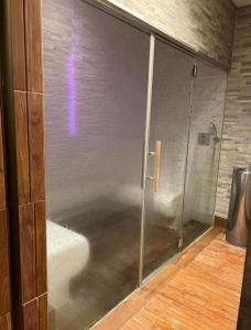 a glass shower door with a purple light on it at Arpadtravel in Budapest