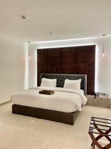 a bedroom with a large bed with a large headboard at Tajreed Suites in Riyadh