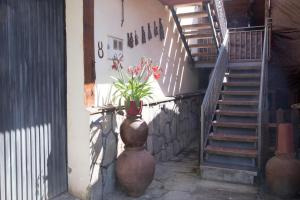 a large vase with a plant in it next to a staircase at La Charca de la Dehesa in Casas del Monte
