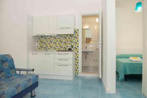 kuchnia z białymi szafkami oraz pokój z łóżkiem w obiekcie Residence La Conchiglia w mieście Vieste