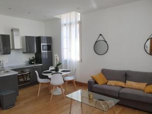 a living room with a couch and a table and a kitchen at L'APPART'JEANNIN HYPER CENTRE in Dijon